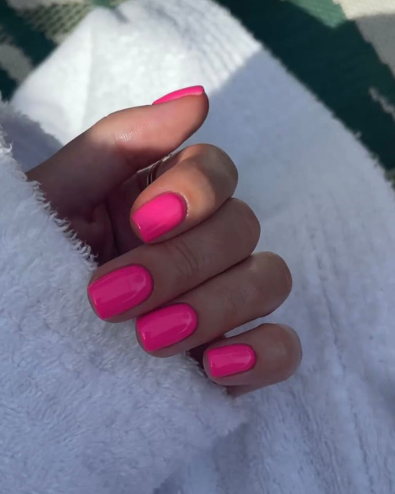 Fuschia gel nails over white fluffy garment by Tori Watterson